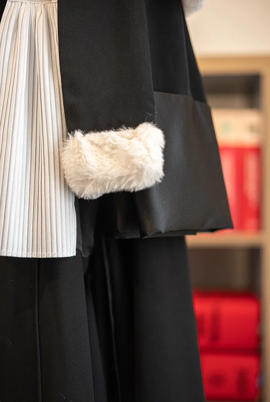 La robe d'avocat du cabinet devant la bibliothèque de codes